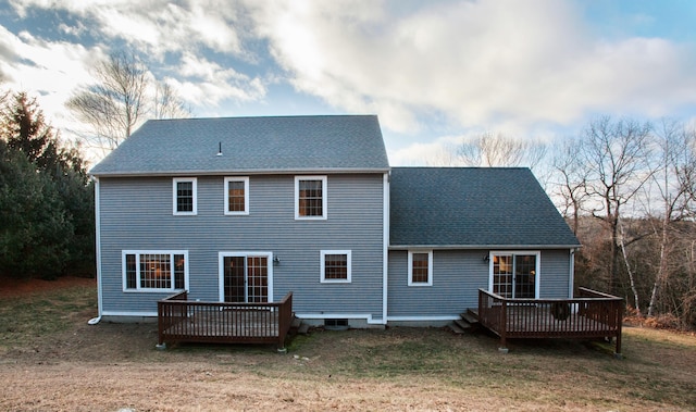 rear view of house featuring a deck and a lawn