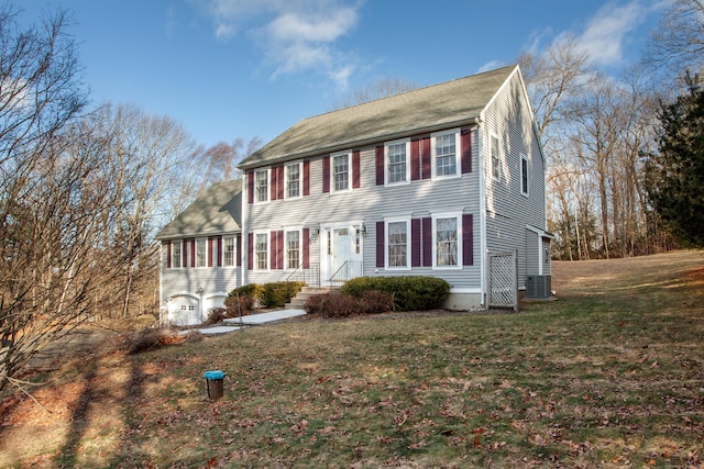 colonial-style house featuring a sunroom, cooling unit, and a front lawn