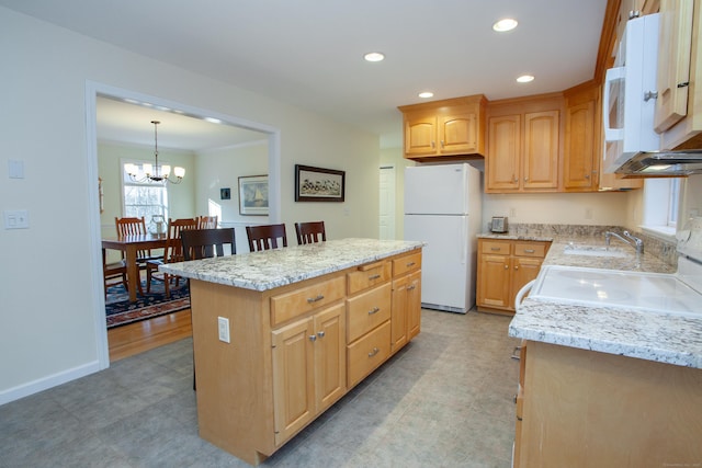 kitchen with sink, a center island, hanging light fixtures, an inviting chandelier, and white refrigerator