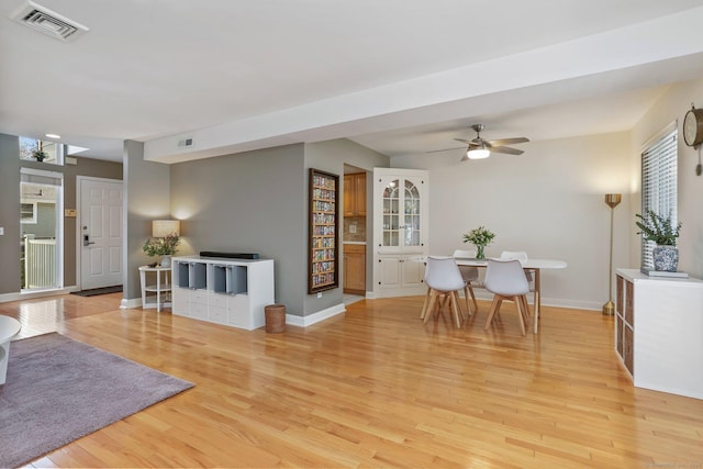 living room featuring ceiling fan and light hardwood / wood-style flooring