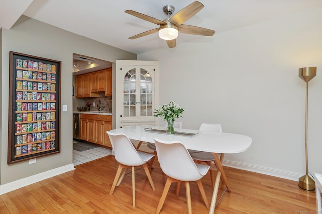 dining room featuring sink, light hardwood / wood-style floors, and ceiling fan