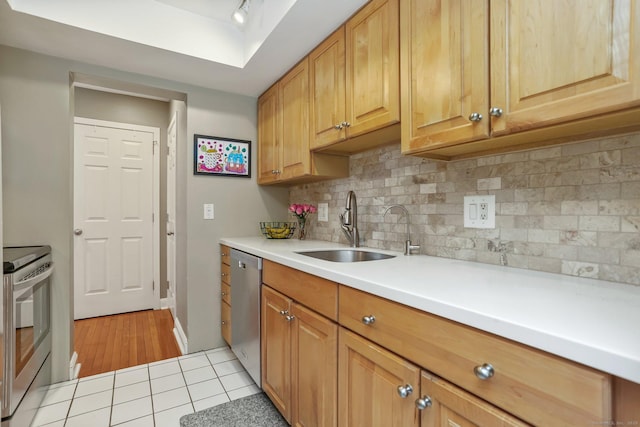 kitchen with tasteful backsplash, appliances with stainless steel finishes, sink, and light tile patterned floors