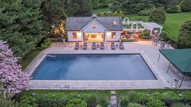 back of house with an outbuilding, a patio, and a fenced in pool