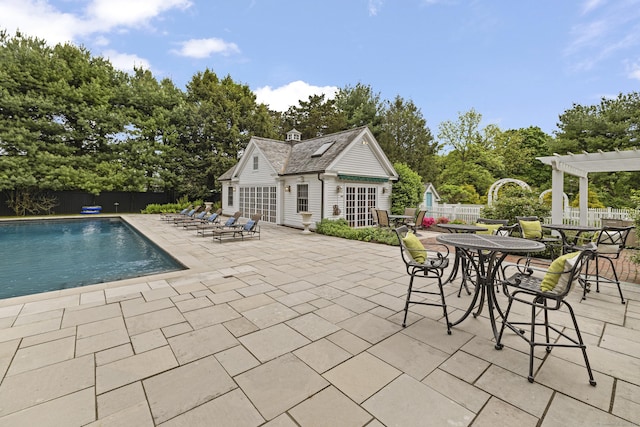 view of pool featuring a pergola, an outbuilding, and a patio