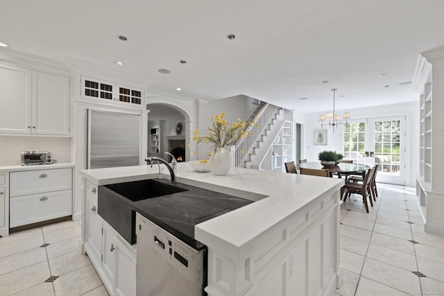 kitchen featuring white cabinets, white dishwasher, tasteful backsplash, and a center island with sink