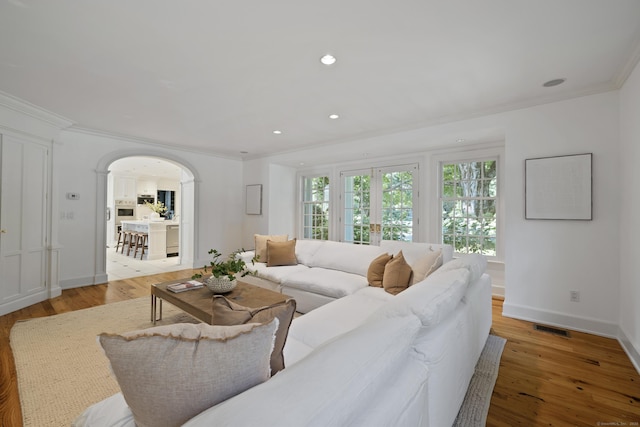 living room with light hardwood / wood-style flooring and ornamental molding