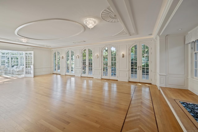 interior space with french doors, light wood-type flooring, and ornamental molding