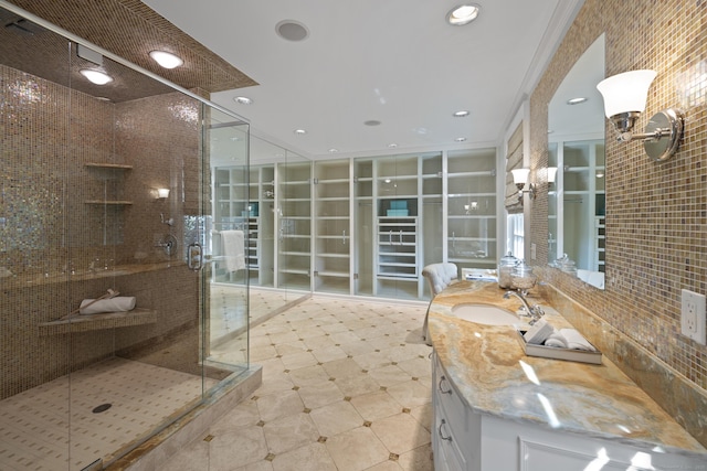 bathroom with vanity, a shower with door, and crown molding