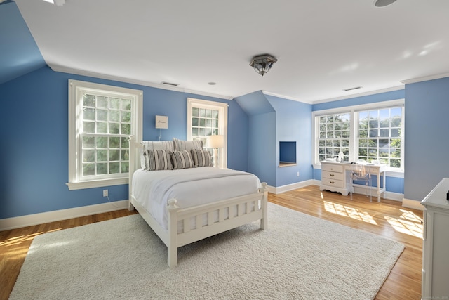 bedroom featuring ornamental molding, vaulted ceiling, and hardwood / wood-style flooring