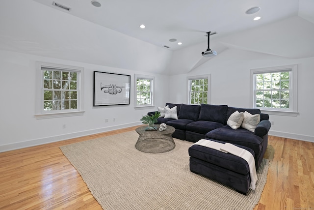 living room featuring lofted ceiling and light hardwood / wood-style flooring