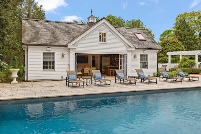 rear view of property featuring a patio area, a fenced in pool, and a pergola