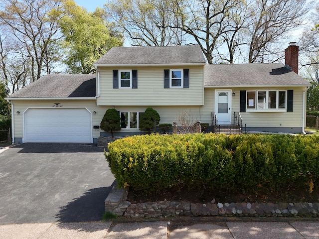 158 Monroe St, East Hartford, CT 06118 - tri-level home with a chimney, asphalt driveway, a garage, entry steps, and roof with shingles