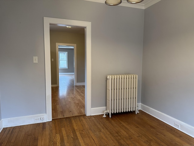 unfurnished room with hardwood / wood-style floors and radiator