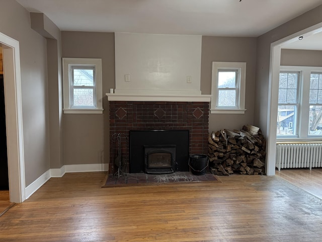 unfurnished living room with hardwood / wood-style floors and radiator heating unit