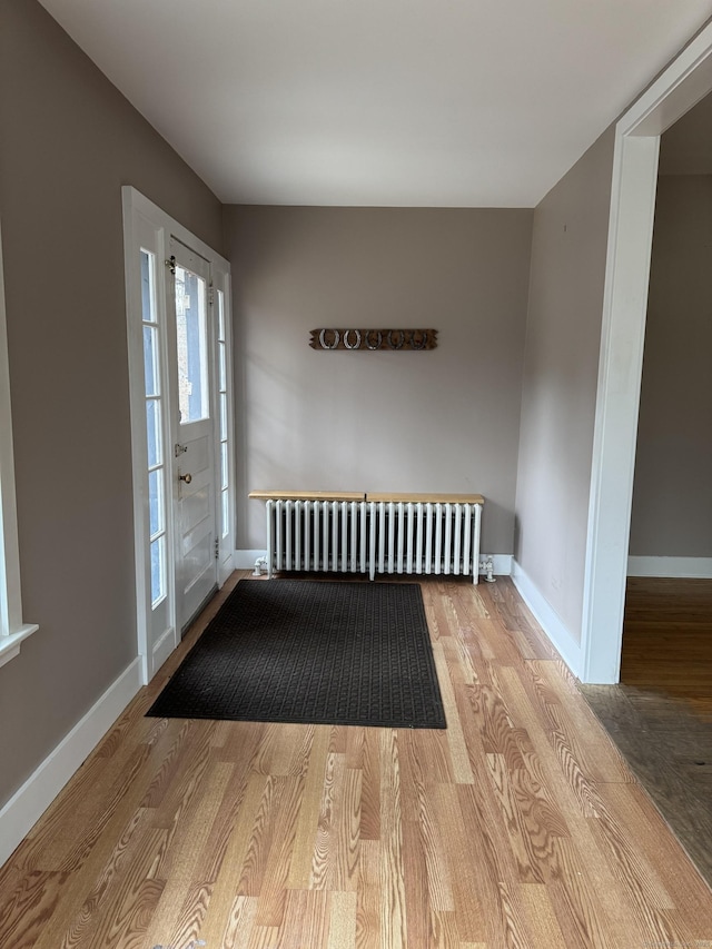 entrance foyer with radiator heating unit and light hardwood / wood-style floors