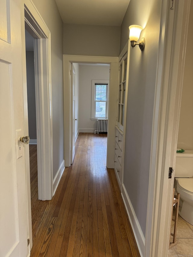 corridor with hardwood / wood-style flooring and radiator