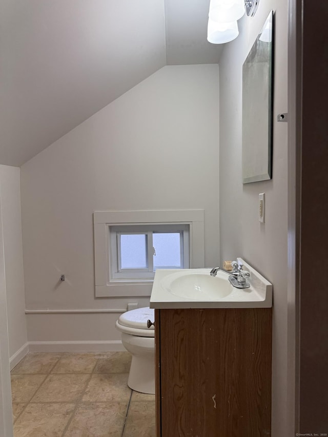 bathroom featuring vanity, toilet, and lofted ceiling