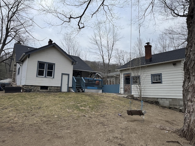 back of house featuring a wooden deck and a lawn