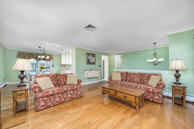 living room featuring light hardwood / wood-style floors, crown molding, and an inviting chandelier