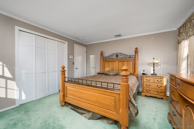 carpeted bedroom with a closet, a textured ceiling, and ornamental molding