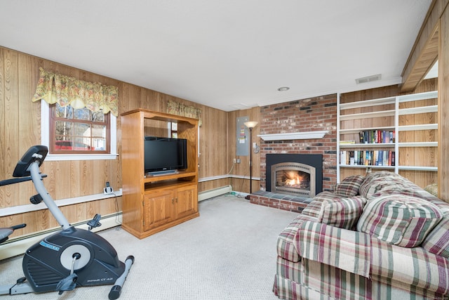 workout area featuring a fireplace, carpet flooring, baseboard heating, and wooden walls