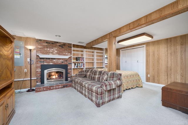 carpeted living room featuring a fireplace and wood walls