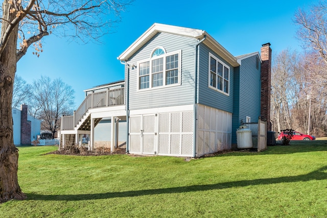 back of property with a lawn and a wooden deck