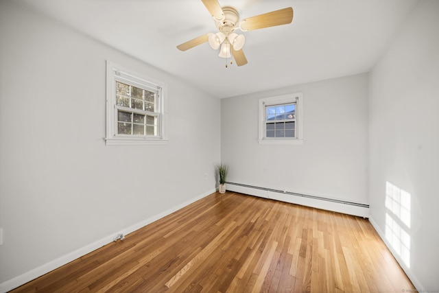 empty room featuring light wood-type flooring, ceiling fan, and a baseboard radiator