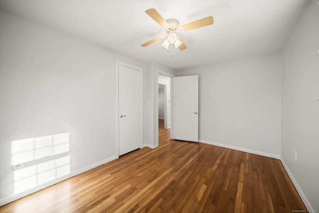 empty room with ceiling fan and hardwood / wood-style floors