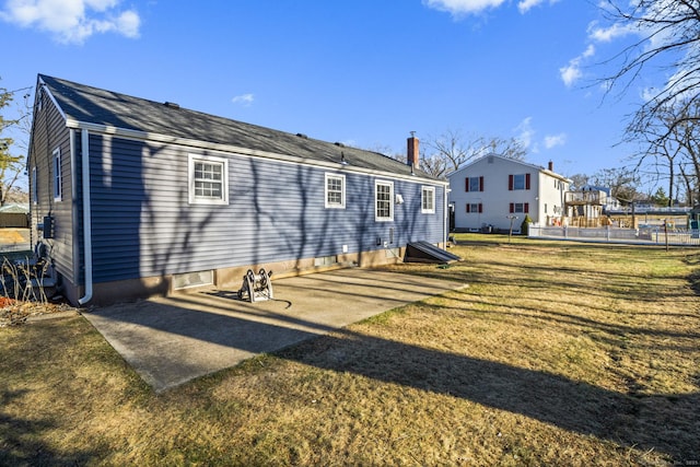 back of property featuring a patio and a lawn