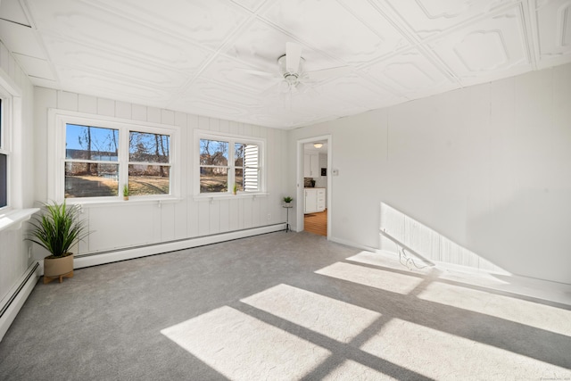 interior space featuring a baseboard heating unit, carpet floors, and ceiling fan