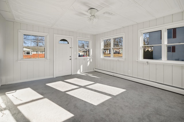 unfurnished sunroom featuring a baseboard radiator and ceiling fan