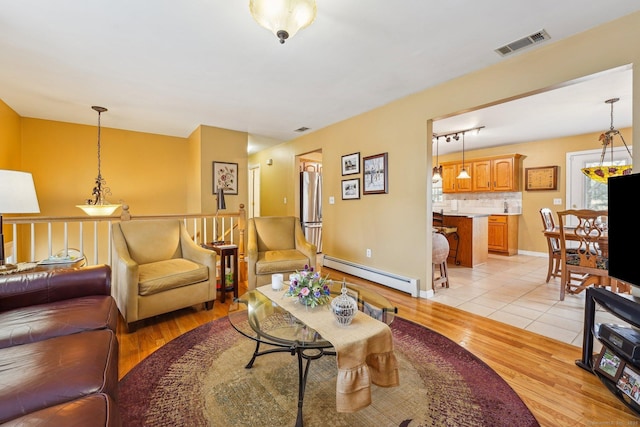 living room with a baseboard radiator and light wood-type flooring