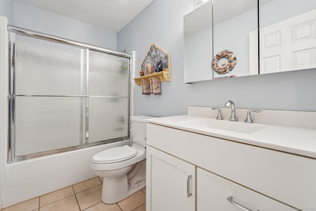 full bathroom featuring tile patterned flooring, bath / shower combo with glass door, vanity, and toilet