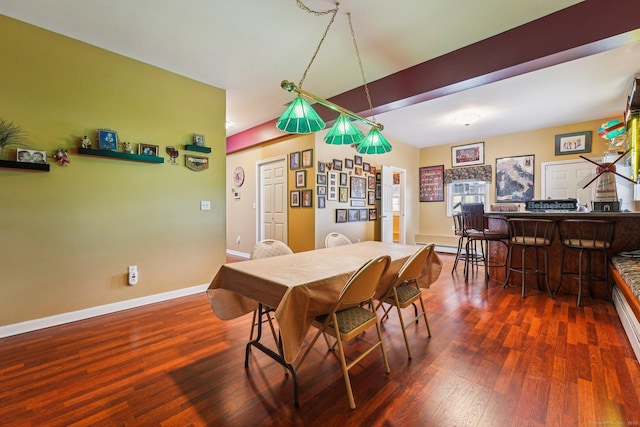 dining area featuring dark wood-type flooring and bar area