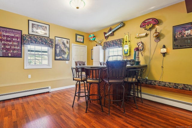 bar featuring a baseboard heating unit, a wealth of natural light, and wood-type flooring