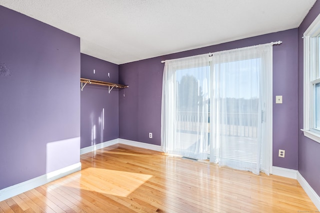 spare room featuring wood-type flooring and a textured ceiling