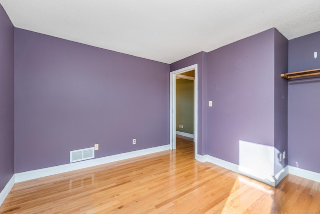 unfurnished room with hardwood / wood-style flooring