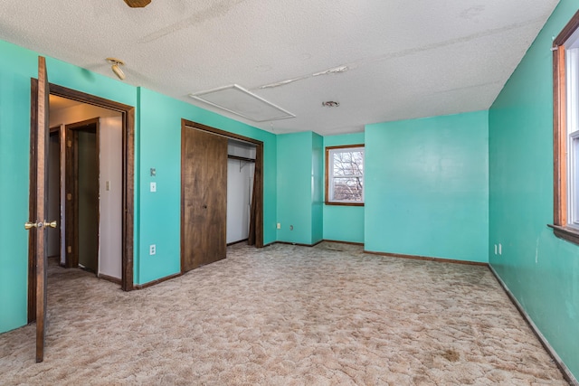 unfurnished bedroom with a textured ceiling, a closet, and light colored carpet