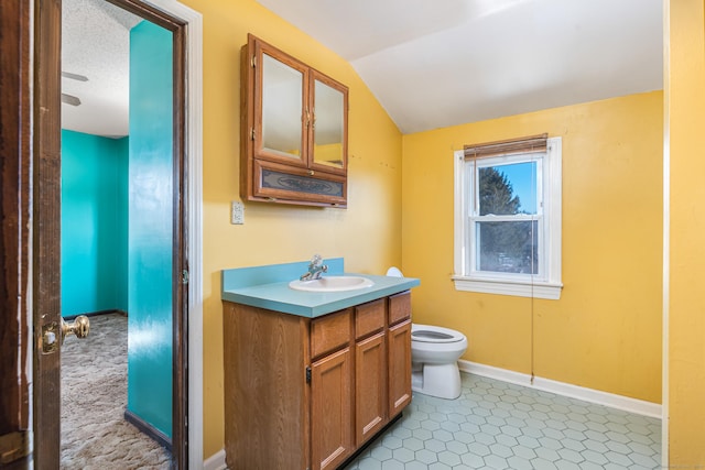 bathroom with lofted ceiling, vanity, toilet, and a textured ceiling