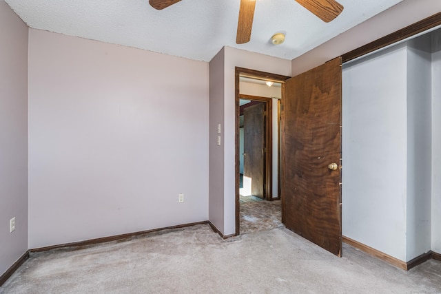 spare room featuring ceiling fan, light carpet, and a textured ceiling