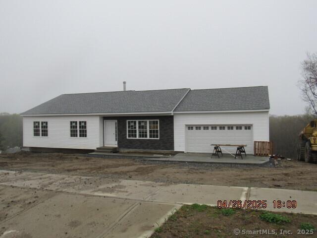 ranch-style home featuring dirt driveway and an attached garage