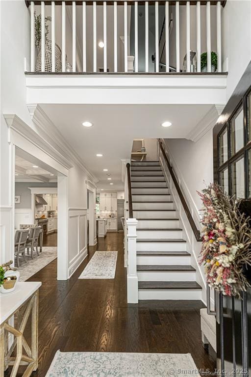 stairs featuring hardwood / wood-style floors and ornamental molding