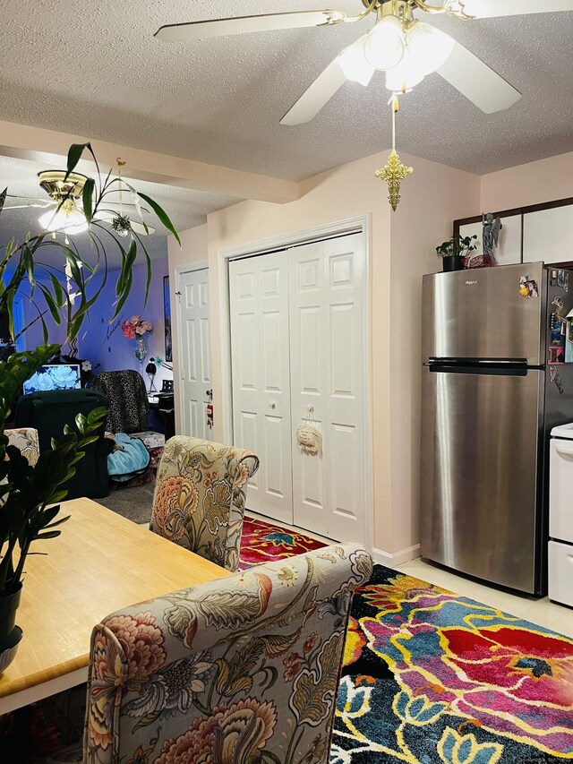 living room with a textured ceiling and ceiling fan