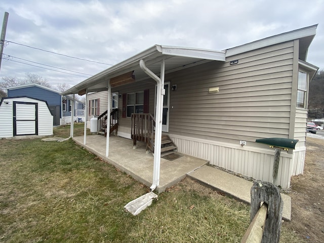 view of side of home with a yard and a storage unit