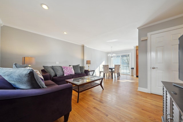 living room with a chandelier, crown molding, and light hardwood / wood-style flooring