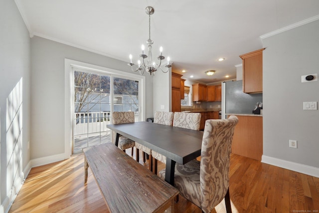 dining room featuring ornamental molding, light hardwood / wood-style flooring, and a chandelier