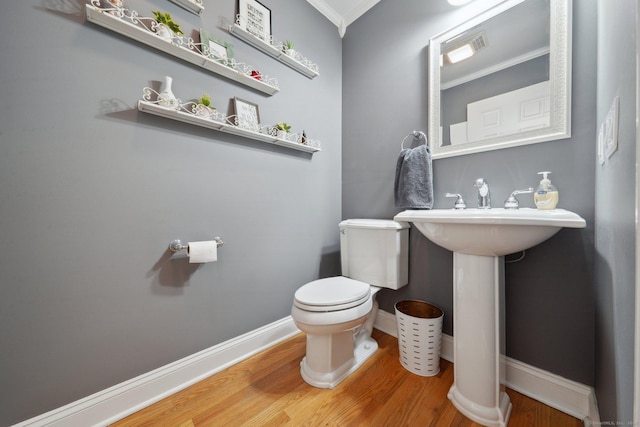 bathroom with toilet, sink, hardwood / wood-style floors, and crown molding