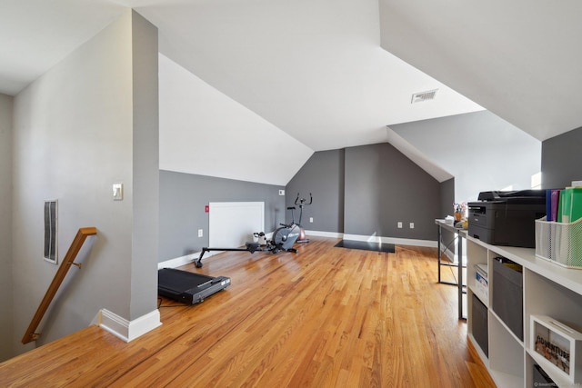 additional living space with hardwood / wood-style floors and vaulted ceiling