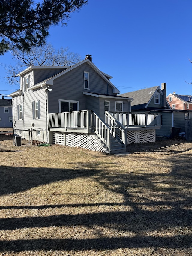 rear view of house featuring a yard and a wooden deck